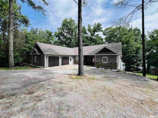 65 Stony Pt, Goreville, IL 62939 - view of front of house featuring an attached garage, stone siding, and driveway