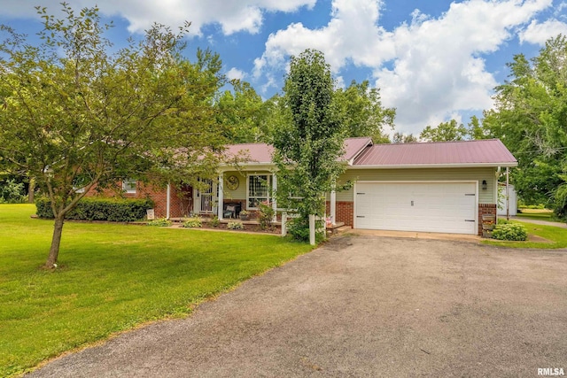 13399 S County Line Rd, West Frankfort, IL 62896 - view of front facade featuring brick siding, driveway, a front yard, a garage, and a metal roof