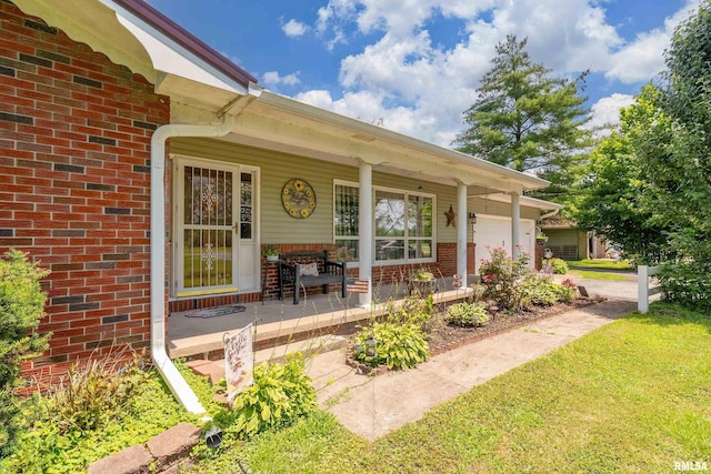 13399 S County Line Rd, West Frankfort, IL 62896 - view of exterior entry with brick siding, an attached garage, covered porch, and concrete driveway