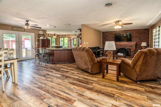 13399 S County Line Rd, West Frankfort, IL 62896 - living room with a ceiling fan, wood-type flooring, a fireplace, and french doors