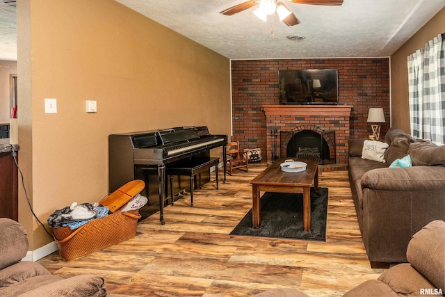 13399 S County Line Rd, West Frankfort, IL 62896 - living room featuring ceiling fan, wood finished floors, a fireplace, and a textured ceiling