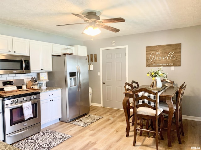 1203 W Goodall St, Marion, IL 62959 - kitchen with stainless steel appliances, white cabinetry, light wood-style flooring, a ceiling fan, and a textured ceiling