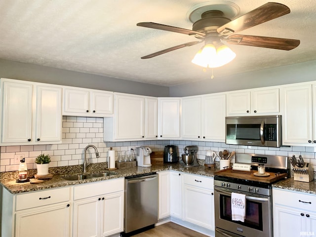 1203 W Goodall St, Marion, IL 62959 - kitchen featuring appliances with stainless steel finishes, decorative backsplash, a ceiling fan, white cabinetry, and dark stone counters