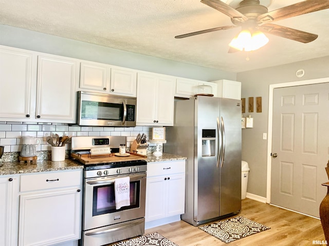 1203 W Goodall St, Marion, IL 62959 - kitchen featuring stainless steel appliances, light wood-style flooring, white cabinets, tasteful backsplash, and a textured ceiling