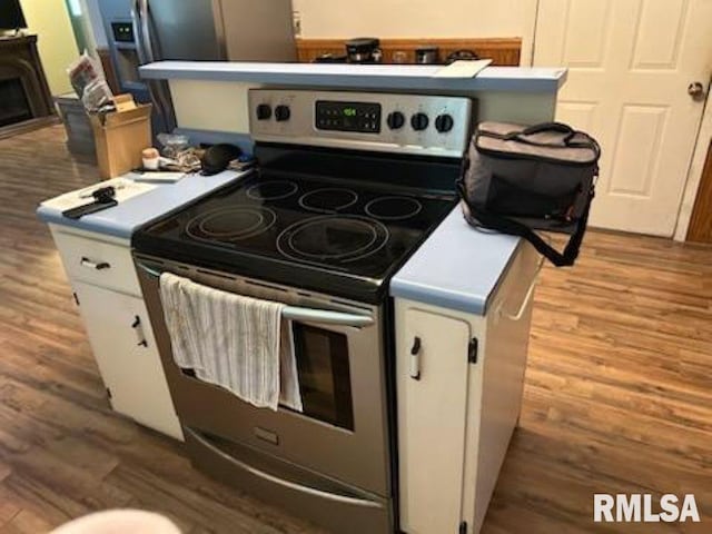 600 W Collins St, Goreville, IL 62939 - kitchen featuring stainless steel electric range, wood finished floors, and white cabinets