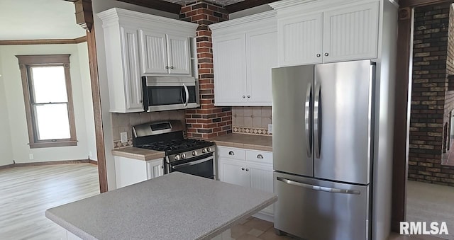202 E 8th St, Mount Carmel, IL 62863 - kitchen with stainless steel appliances, decorative backsplash, white cabinets, and crown molding
