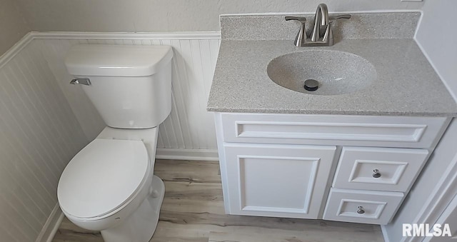 202 E 8th St, Mount Carmel, IL 62863 - half bath with wood finished floors, vanity, wainscoting, and a decorative wall
