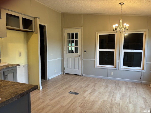 2780 Campground Rd, Anna, IL 62906 - unfurnished dining area with light wood finished floors, a chandelier, crown molding, and a textured ceiling