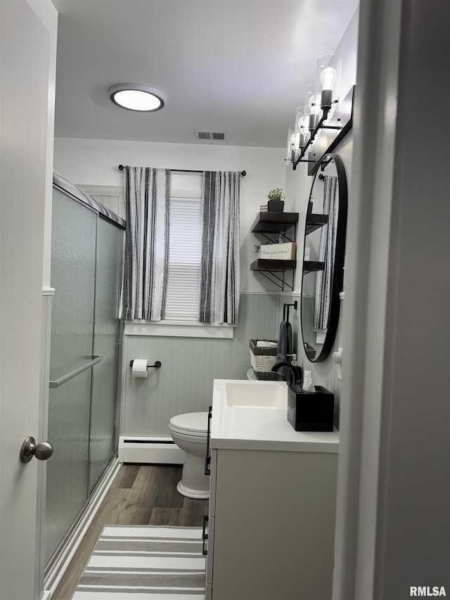 510 Morgan St, Anna, IL 62906 - bathroom featuring a baseboard heating unit, wood finished floors, vanity, a stall shower, and a wainscoted wall
