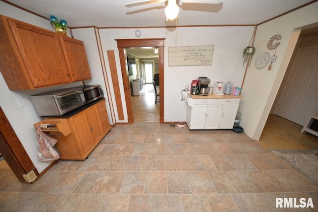 793 County Road 635 E, Wayne City, IL 62895 - kitchen with ceiling fan, brown cabinets, stone finish floors, ornamental molding, and dark countertops