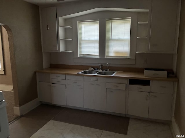 415 S 4th St, Mount Vernon, IL 62864 - kitchen featuring open shelves, white cabinetry, light countertops, and light marble finish floors