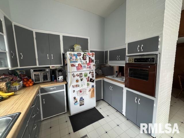 303 Elles Ave, Carterville, IL 62918 - kitchen featuring oven, freestanding refrigerator, gray cabinetry, light countertops, and light flooring