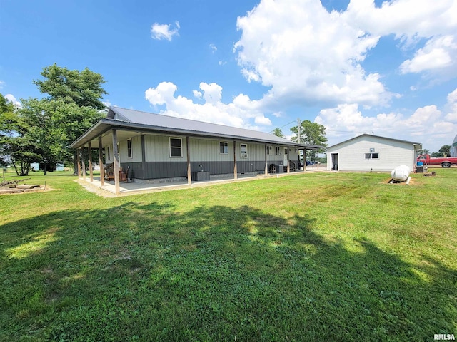 232 Palm Ln, Flora, IL 62839 - rear view of house featuring a lawn, board and batten siding, and a metal roof