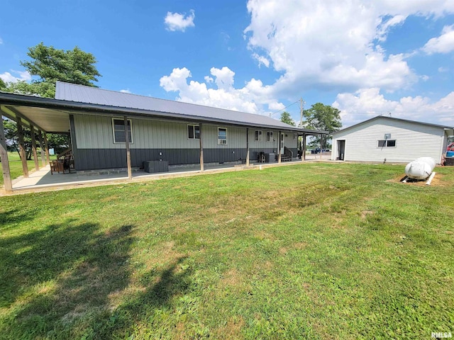 232 Palm Ln, Flora, IL 62839 - rear view of house with board and batten siding, a lawn, a patio area, and a metal roof