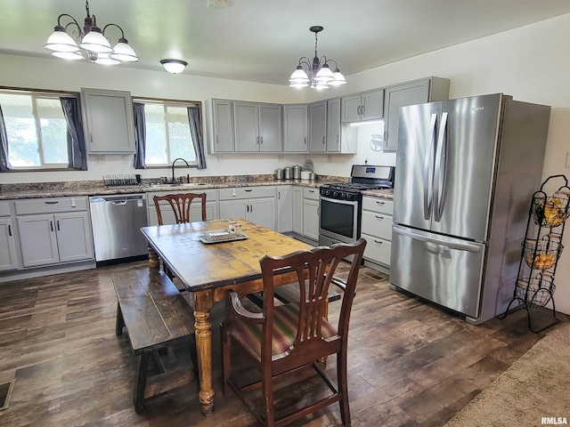 232 Palm Ln, Flora, IL 62839 - kitchen featuring appliances with stainless steel finishes, a chandelier, dark wood finished floors, gray cabinetry, and decorative light fixtures