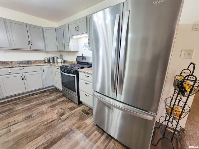 232 Palm Ln, Flora, IL 62839 - kitchen with appliances with stainless steel finishes, dark wood-style floors, light stone counters, and gray cabinets