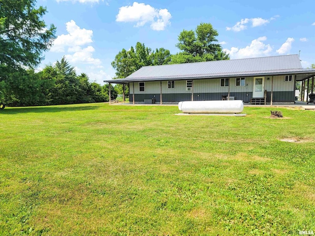 232 Palm Ln, Flora, IL 62839 - rear view of property with board and batten siding, a lawn, and a metal roof