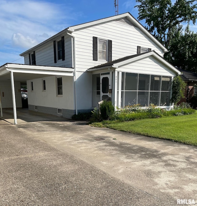 901 W Elm St, Carmi, IL 62821 - view of front of house with a sunroom, a carport, driveway, and a front lawn