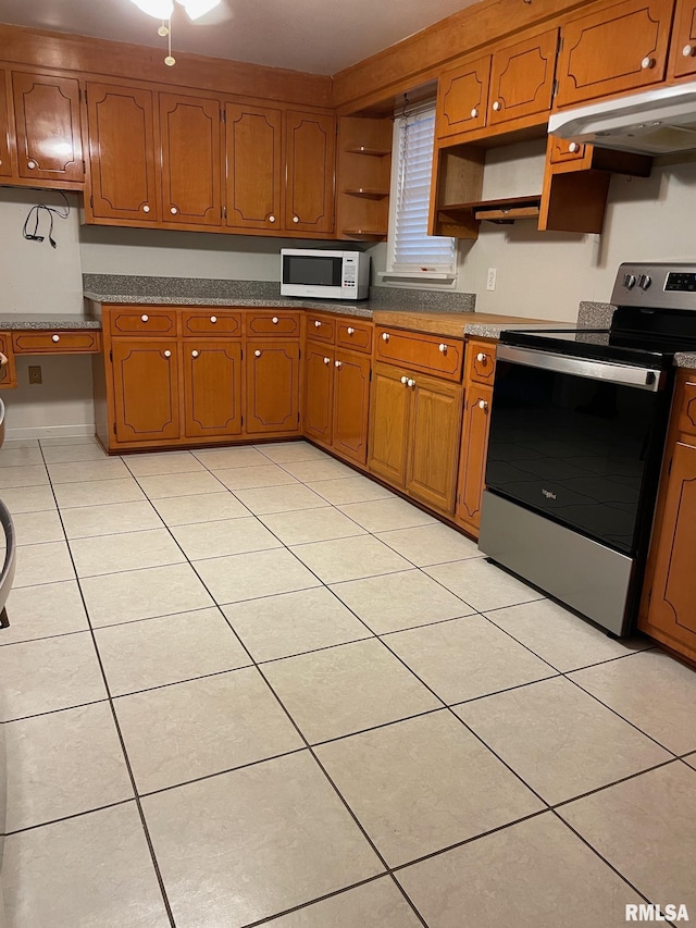 901 W Elm St, Carmi, IL 62821 - kitchen with stainless steel range with electric cooktop, white microwave, open shelves, light tile patterned flooring, and brown cabinetry
