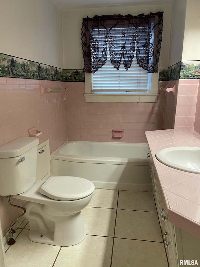 901 W Elm St, Carmi, IL 62821 - bathroom with a tub, tile patterned floors, tile walls, vanity, and a wainscoted wall