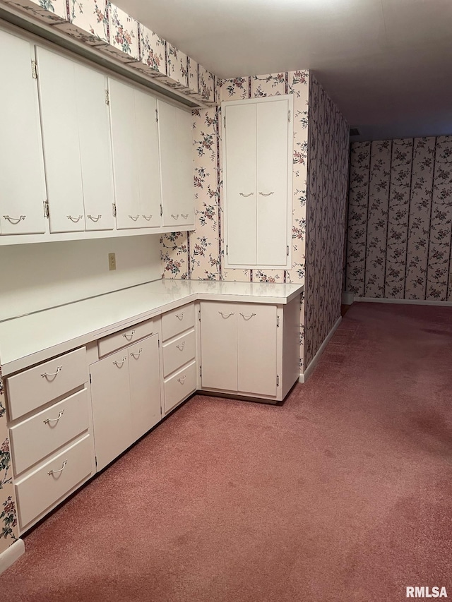 901 W Elm St, Carmi, IL 62821 - kitchen with wallpapered walls, light colored carpet, light countertops, and white cabinetry