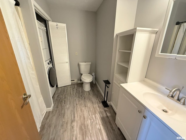 1002 Elm St, Marion, IL 62959 - bathroom featuring estacked washer and dryer, vanity, wood finished floors, a baseboard radiator, and a closet