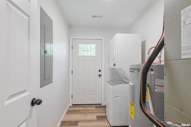 302 S Gray Dr, Carbondale, IL 62901 - laundry area with electric water heater, light wood-style floors, heating unit, stacked washer / drying machine, and electric panel