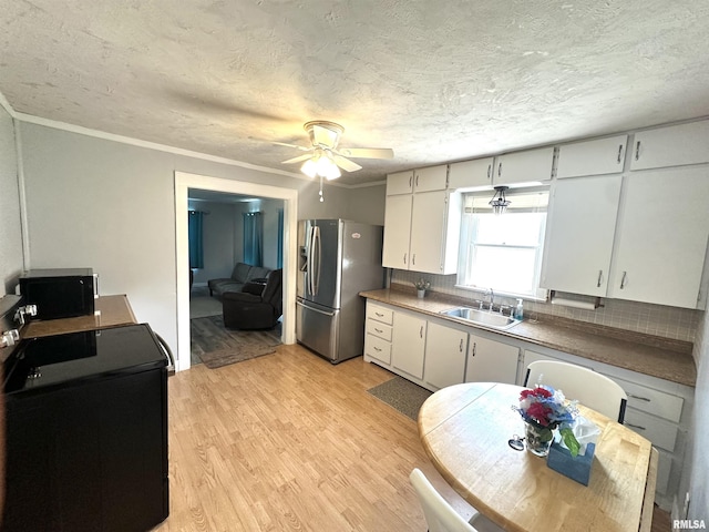 2448 E State Route 161st Rte, Centralia, IL 62801 - kitchen with range, stainless steel fridge with ice dispenser, black microwave, light wood finished floors, and a ceiling fan