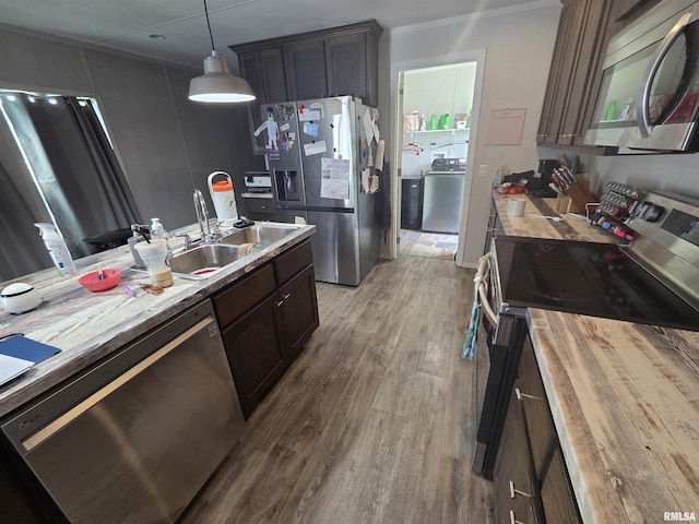 303 N Marion St, Centralia, IL 62801 - kitchen with appliances with stainless steel finishes, washer / dryer, wood counters, wood finished floors, and pendant lighting