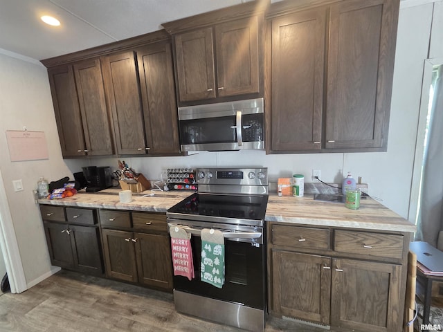 303 N Marion St, Centralia, IL 62801 - kitchen featuring appliances with stainless steel finishes, wood finished floors, dark brown cabinetry, and recessed lighting