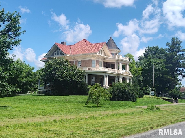 319 High St, Mound City, IL 62963 - view of property exterior featuring a balcony, a lawn, and a chimney