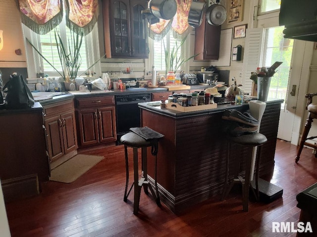 319 High St, Mound City, IL 62963 - kitchen with dark wood-style flooring, black dishwasher, a breakfast bar, and plenty of natural light