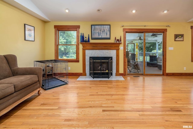 243 Pump Station Rd, Makanda, IL 62958 - living area featuring wood finished floors, a tiled fireplace, ceiling fan, healthy amount of natural light, and vaulted ceiling