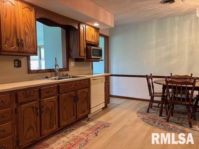 15944 Moellers Rd, Marion, IL 62959 - kitchen with white dishwasher, stainless steel microwave, light countertops, and light wood finished floors