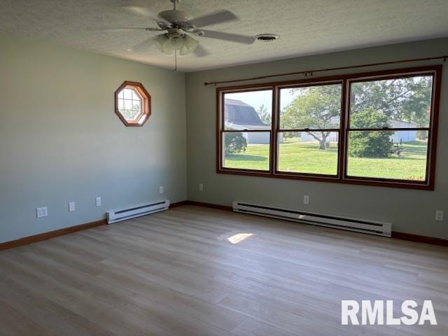 15944 Moellers Rd, Marion, IL 62959 - empty room with a baseboard heating unit, a ceiling fan, wood finished floors, and a textured ceiling