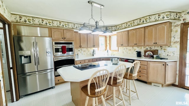 1016 Michael Ln, West Frankfort, IL 62812 - kitchen featuring stainless steel appliances, light countertops, plenty of natural light, wallpapered walls, and a center island