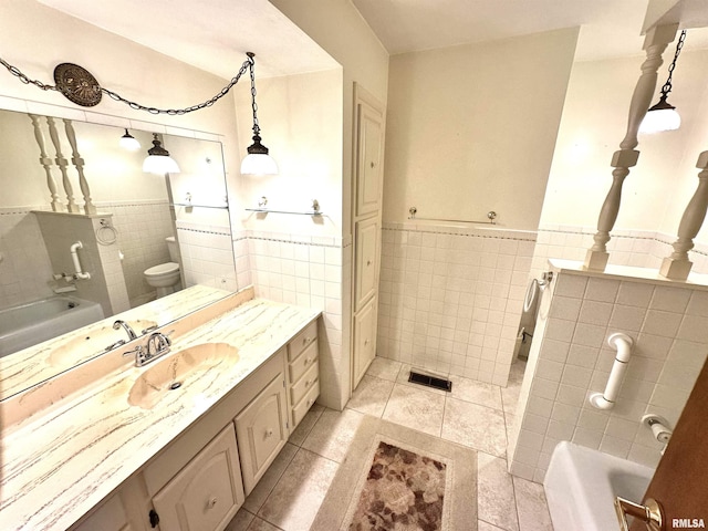 1915 W 4th St, Centralia, IL 62801 - bathroom featuring tile walls, a tub, vanity, tile patterned floors, and wainscoting