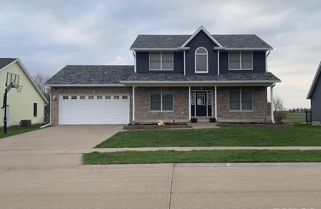 418 Michelle Ln, Walcott, IA 52773 - traditional-style home featuring concrete driveway, a garage, a front lawn, brick siding, and roof with shingles