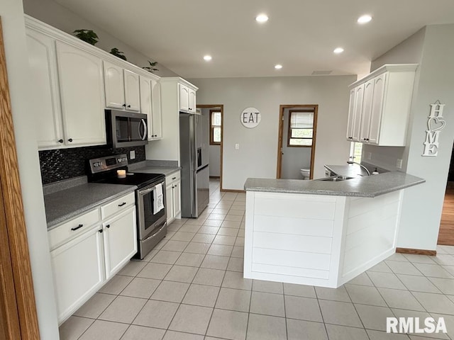 418 Michelle Ln, Walcott, IA 52773 - kitchen featuring appliances with stainless steel finishes, white cabinets, light tile patterned floors, tasteful backsplash, and recessed lighting