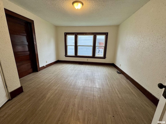 1100 E 2nd St, Centralia, IL 62801 - spare room with a textured wall, a textured ceiling, and wood finished floors