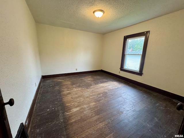 1100 E 2nd St, Centralia, IL 62801 - empty room with a textured ceiling, dark wood-style floors, and a textured wall