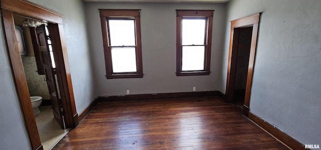 232 N James Ave, Centralia, IL 62801 - unfurnished bedroom with multiple windows, dark wood-style flooring, and ensuite bathroom