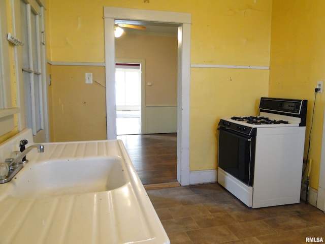 kitchen with ceiling fan, dark tile flooring, and white range with gas cooktop