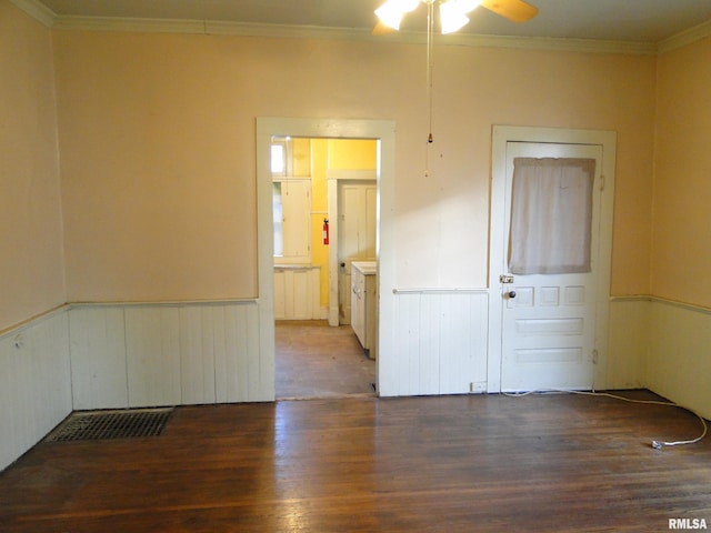 empty room with dark wood-type flooring, ceiling fan, and ornamental molding