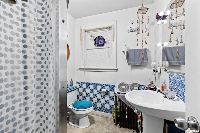 bathroom featuring tile walls, toilet, and tile floors