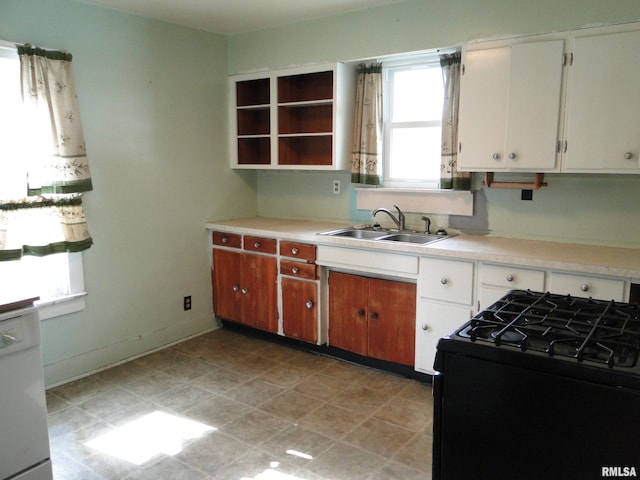 kitchen with gas stove, white dishwasher, a healthy amount of sunlight, sink, and white cabinetry