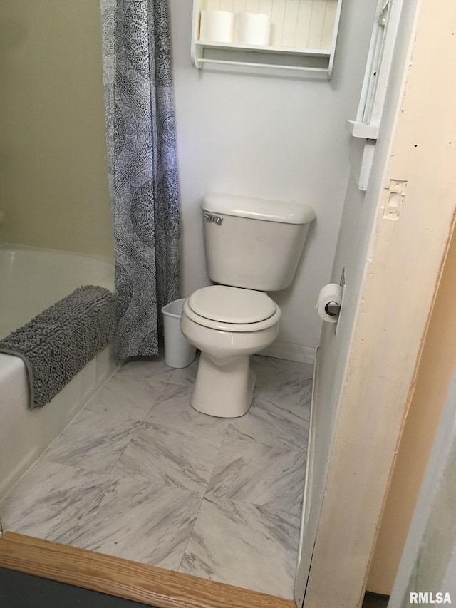 bathroom featuring toilet and a shower with shower curtain