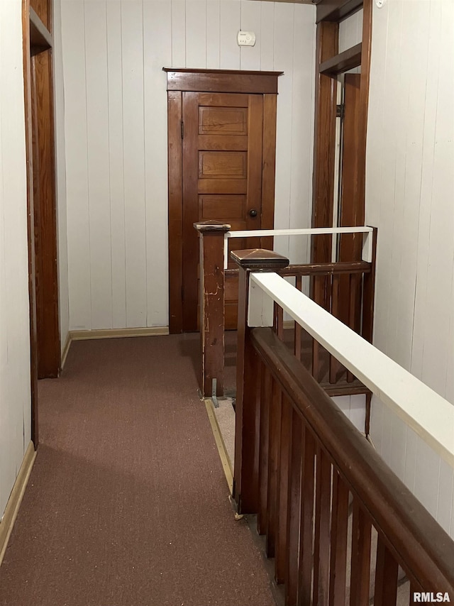 corridor with carpet flooring and wooden walls