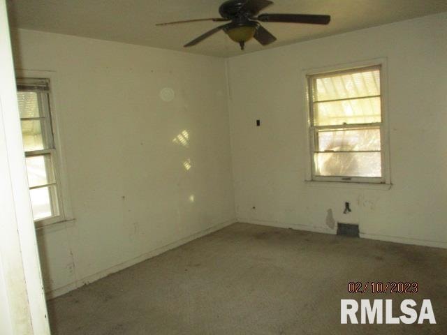 carpeted empty room with a healthy amount of sunlight and ceiling fan