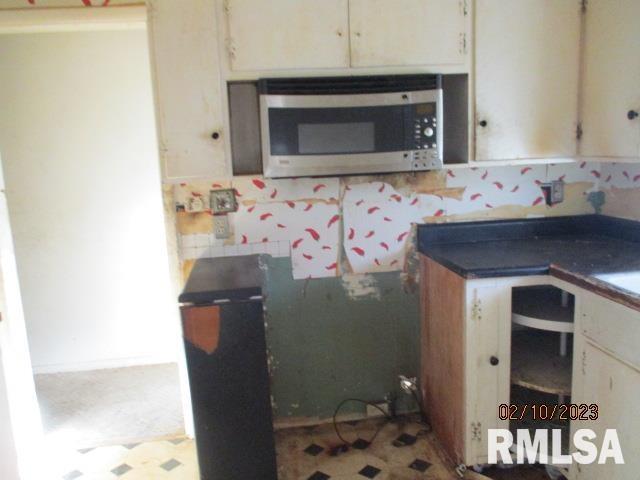 kitchen featuring dark countertops and stainless steel microwave